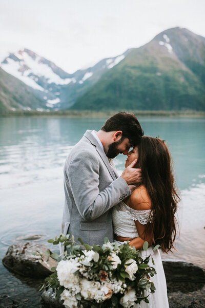 wedding couple hugging on rocky cliff in Hope Alaska after their wedding