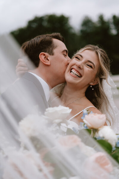 Groom giving bride a kiss on the cheek