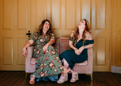 NJ Wedding Photographers Sam and Lisa sitting on a velvet pink couch laughing together