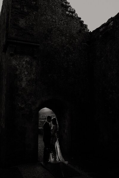 bride and groom embracing in dark door way
