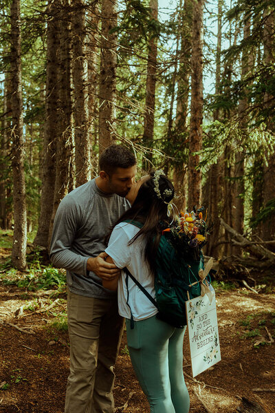 Colorado elopement couple kissing in woods