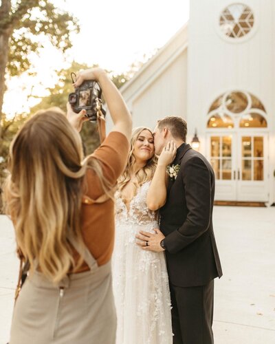 photographer taking photo of bride and groom