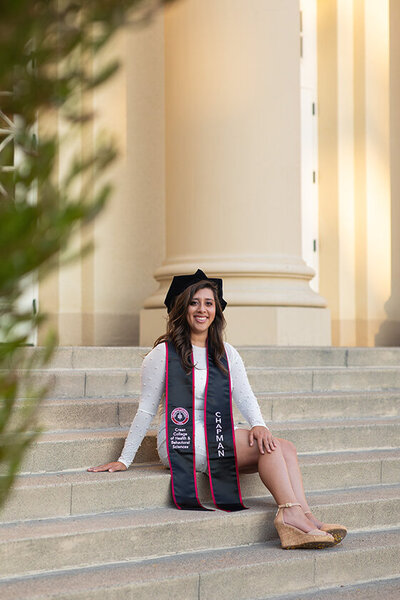 PhD grad smiling on campus at Chapman University