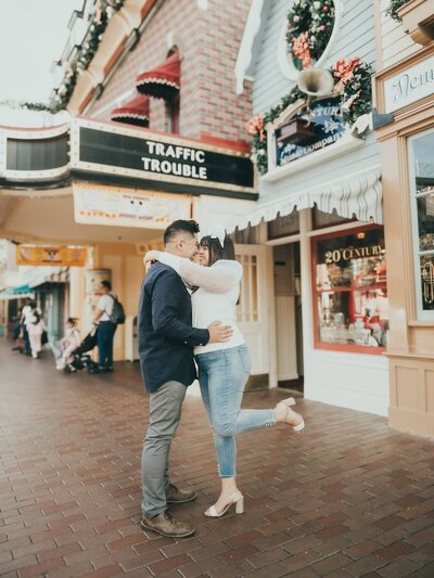 Engagement photos taken on Main Street at Disneyland featuring a couple.