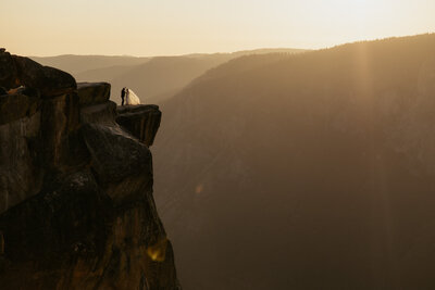Bride and groom eloping standing on cliff at taft point in yosemite national park