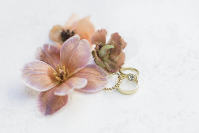 vintage inspired wedding rings with flowers in a flat lay by Kortney Boyett Photography