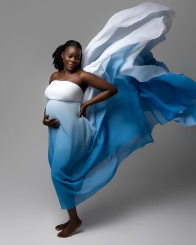 woman with sexy messy hair wearing black off-the-shoulder fitted maternity gown for a classic, editorial look.