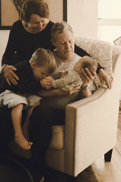 A gorgeous family moment of grandparents holding their grandchildren in their Auckland home. Portrait captured by Eilish Burt Photography