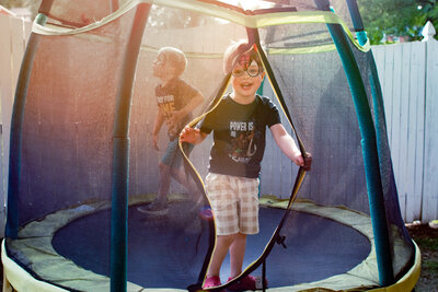 Kid smiling while jumping on a trampoline