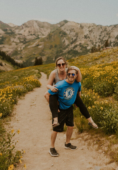 A couple in the mountains giving a piggyback