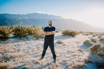 man standing with his arms crossed and his legs apart