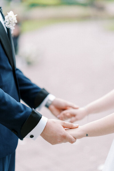 Close-up of bride and groom holding hands during their wedding ceremony in Ajax, Ontario, captured by a Toronto wedding photographer