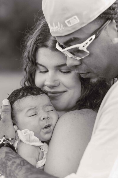 Greyscale image of family snuggling their faces close together