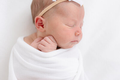 portrait of a sleeping newborn baby girl with her hands by her face taken by missy marshall