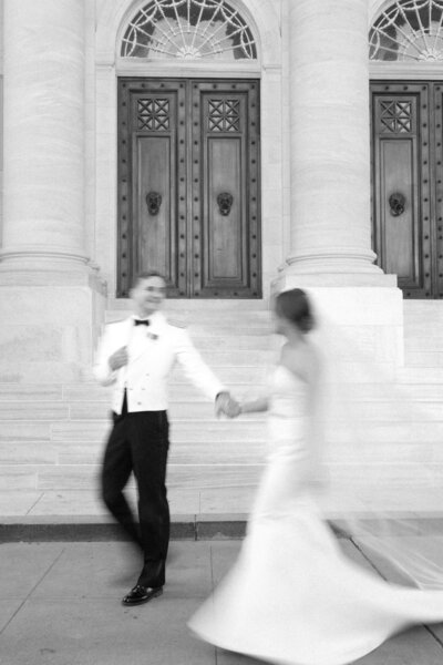 Bride and groom walk hand in hand outside of the DAR Constitution Hall in Washington DC
