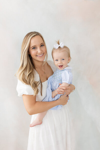 Mom holding baby girl in studio