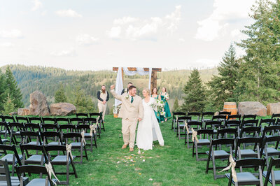 Bride and groom sharing a moment after their wedding ceremony at barn at mader farm in genesee idaho where they are walking away and holding hands