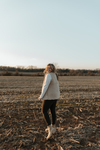 carly hudson standing in field for engagement photography in westminster maryland