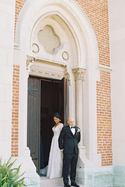 bride and groom praying outside of saint john the evangelist in indianapolis before their catholic wedding mass