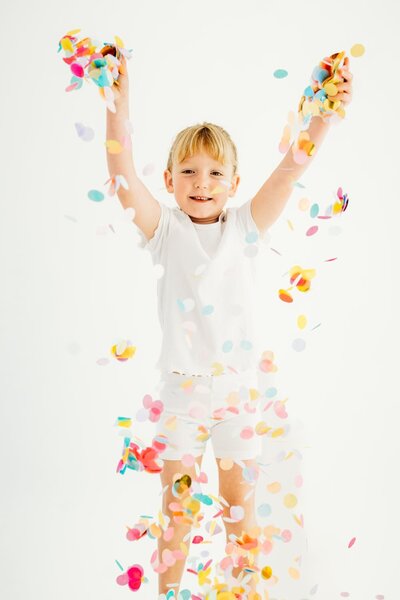 toddler holding wildflowers smiling in the field