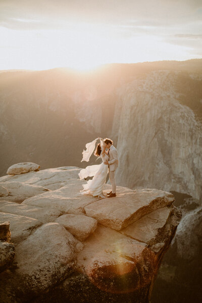 Couple stand together on the edge of a cliff at Taft Point