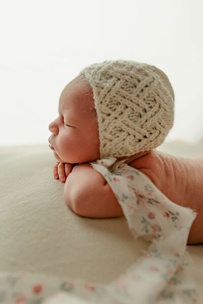 profile shot of baby girl with a knit bonnet sleeping