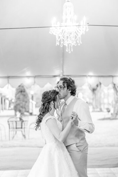 Groom kissing his bride's forehead during their first dance.