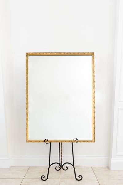 Gold rectangular mirror on black easel stand