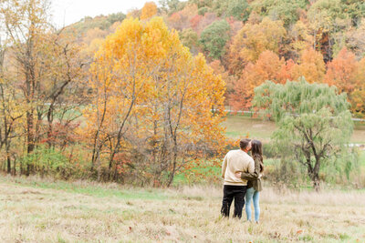 Couple standing in a field of trees at their fall engagement session in Latrobe, PA