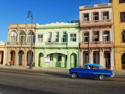 A classic blue car cruising past pastel-colored colonial buildings on the Malecón in Havana ©Stephanie Dosch | theViatrix Cuba Private Luxury Travel
