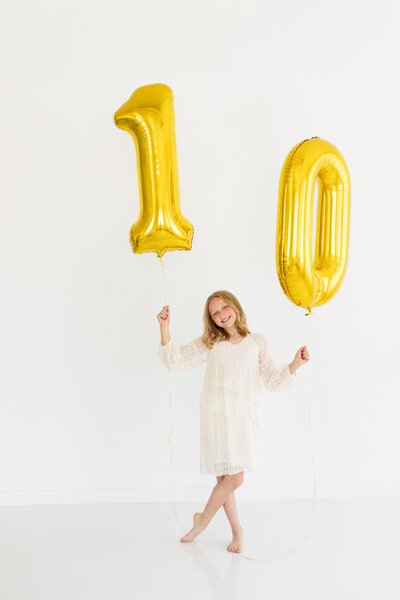 Baby surrounded by ballons sitting in Boise photography studio.