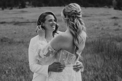 photo of two brides embracing while standing in a field taken by Elopement photographer in estes park