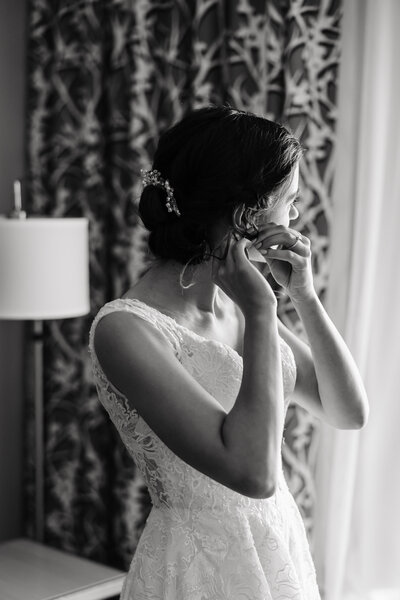 Bride putting an earring in her before walking down the aisle