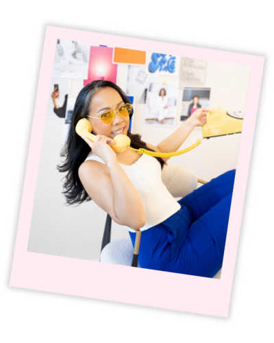 Brand photographer for entrepreneurs seated in a bold yellow chair with branded visuals on the wall, wearing yellow glasses and a matching outfit