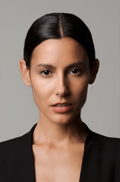 close-up of chic woman in the studio wearing a black suit looking at the camera