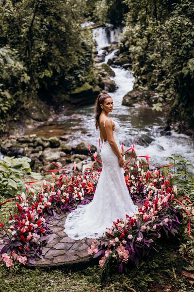 bride and groom standing in front of pink flowers