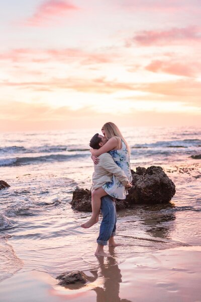 bride jumps into grooms arms on the beach