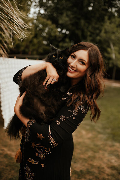 Family photographer Aspen Dawn holding her black cat.