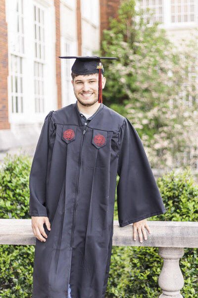 Graduate poses in cap and gown