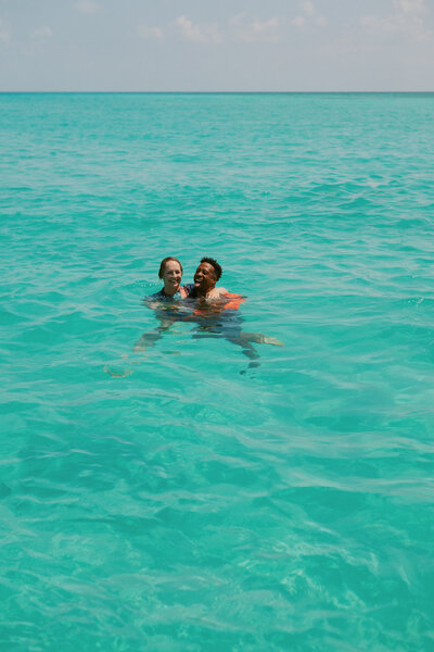 Couple swimming in the Mexico ocean the day before their wedding