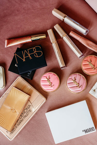 different makeup and beauty products laid out beautifully on a couch. 