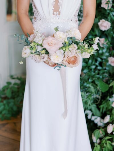 bride holding her blush and white bouquet