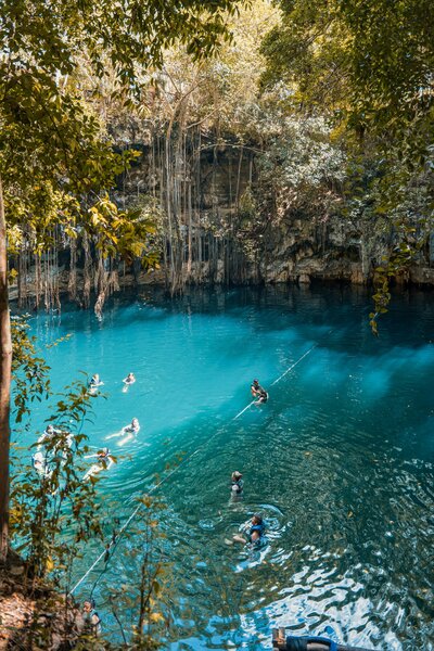 yoga retreat attendees swimming in a cenote in Mexico