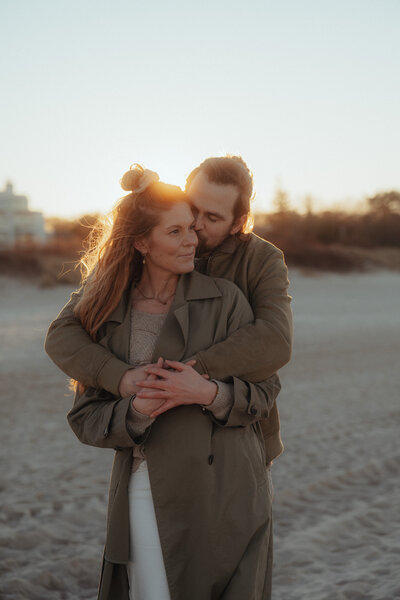 Ein romantischer Moment am Ahlbecker Strand: Zwei Menschen blicken auf das Meer im Abendlicht.