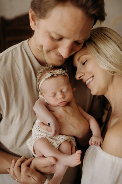 Mother in a long flowy dress holding her newborn in the Rancince Business Center Studio.