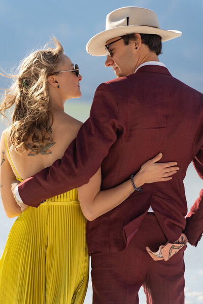 A couple standing side by side with their arms around each other