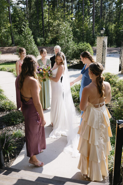 a couple in their wedding clothes standing in front of greenery