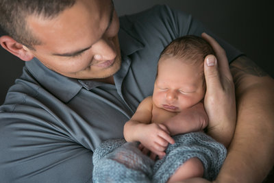 Dad holding newborn wrapped in swaddle