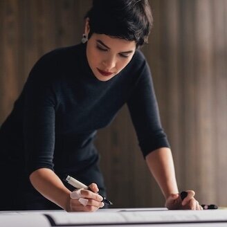 devoted architect in her office balances marketing for architects and design work
