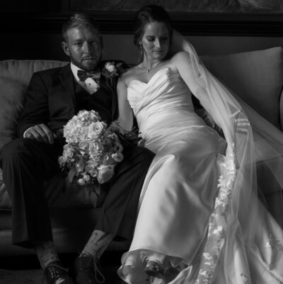 Bride and groom sitting closely on a couch
